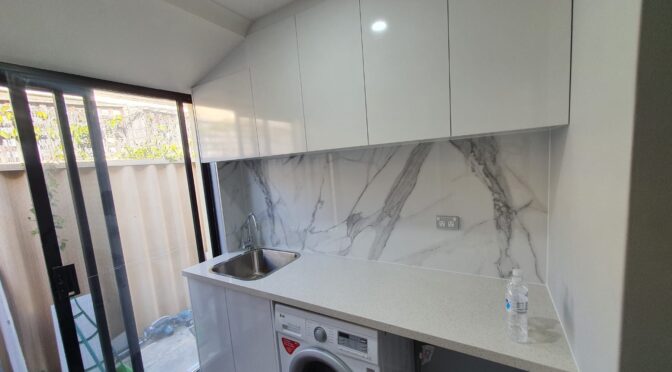 Complete laundry setup with stone top and splasback