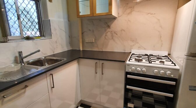 Small city kitchen with stone top and splasback
